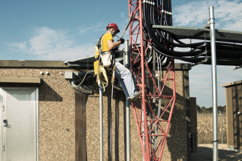 worker in yellow hat climbing tower